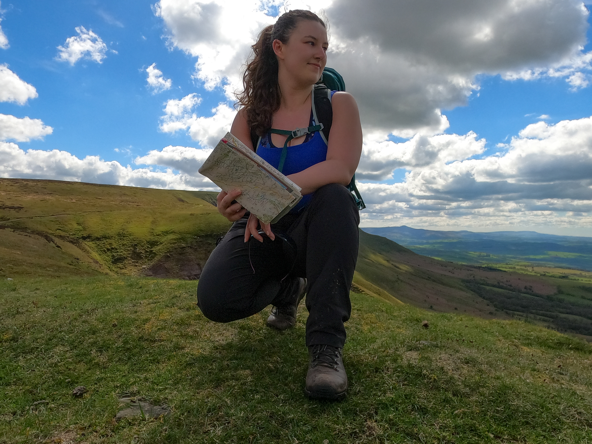 White footprints and white triskele in the middle on a black background, with the text 'A Woman Walks' in white beneath