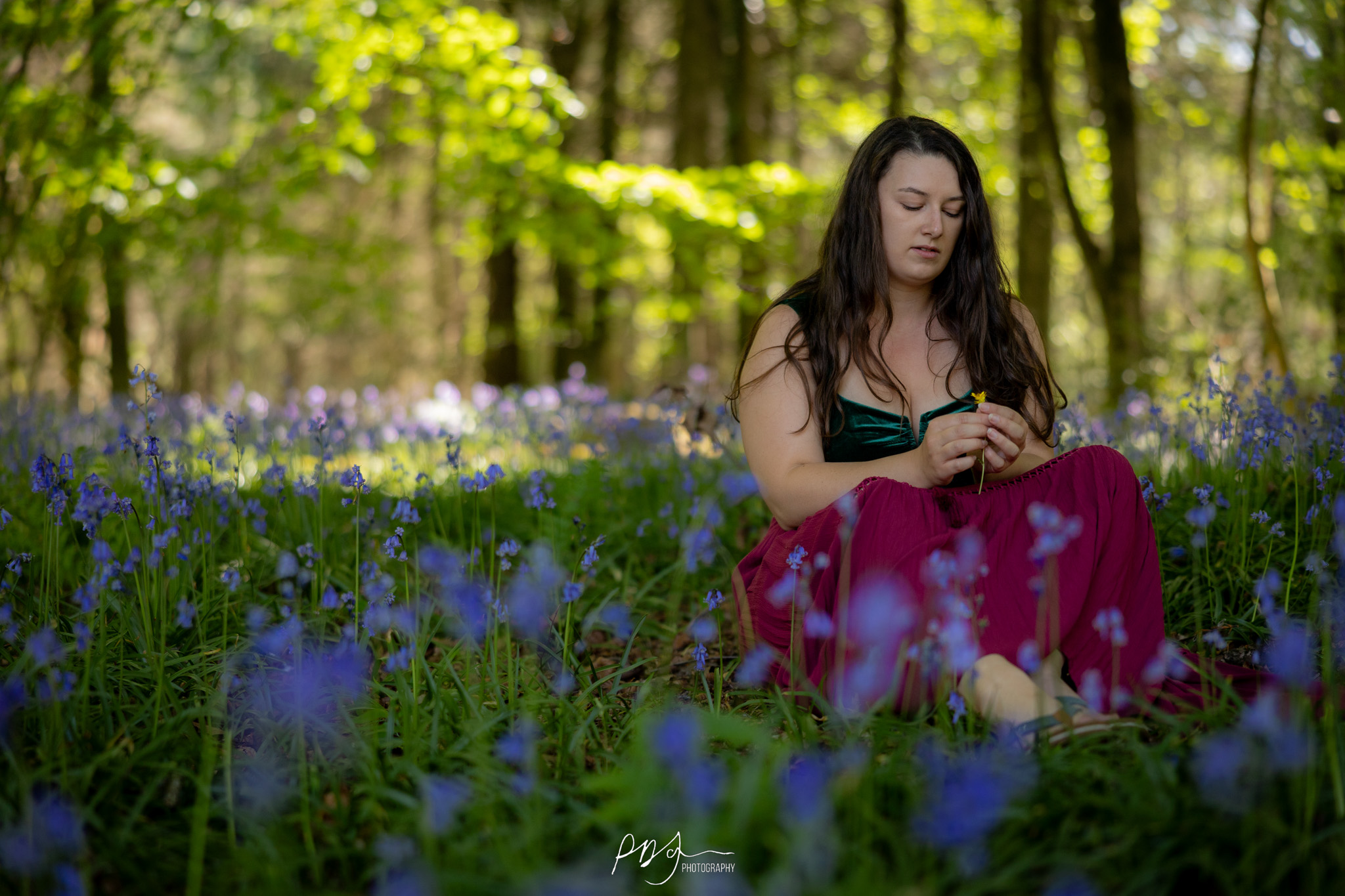 Woman in a pink dress and hiking boots standing on a log in the forest