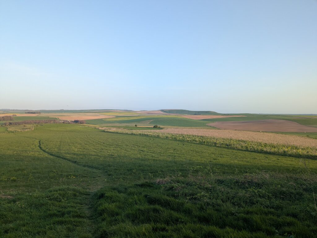 Rolling green plains in the English countryside, under a clear blue sky